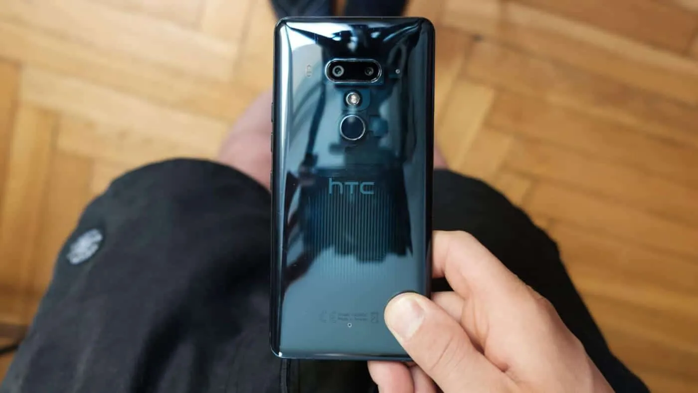 Tył telefonu HTC U12+ z przezroczystą obudową, trzymany w dłoni